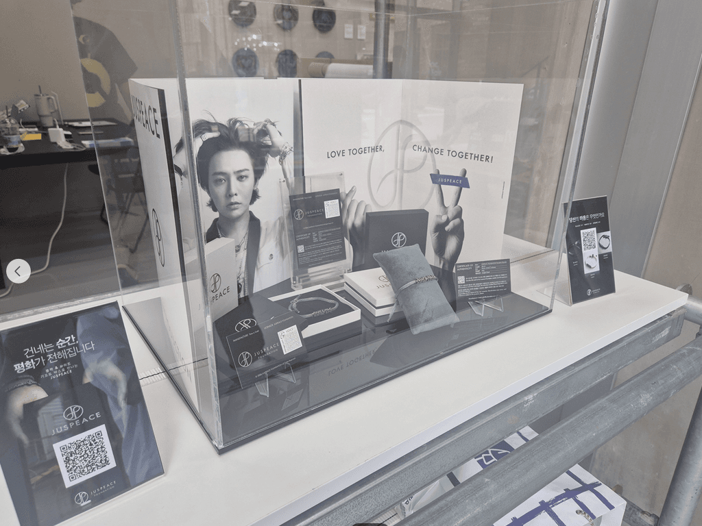 JUSPEACE retail display with bracelets and campaign artwork
